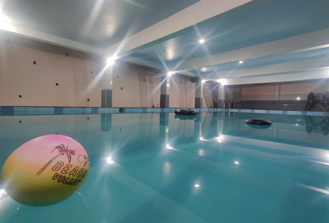 Aquamarine indoor swimming pool with a beach ball in the foreground